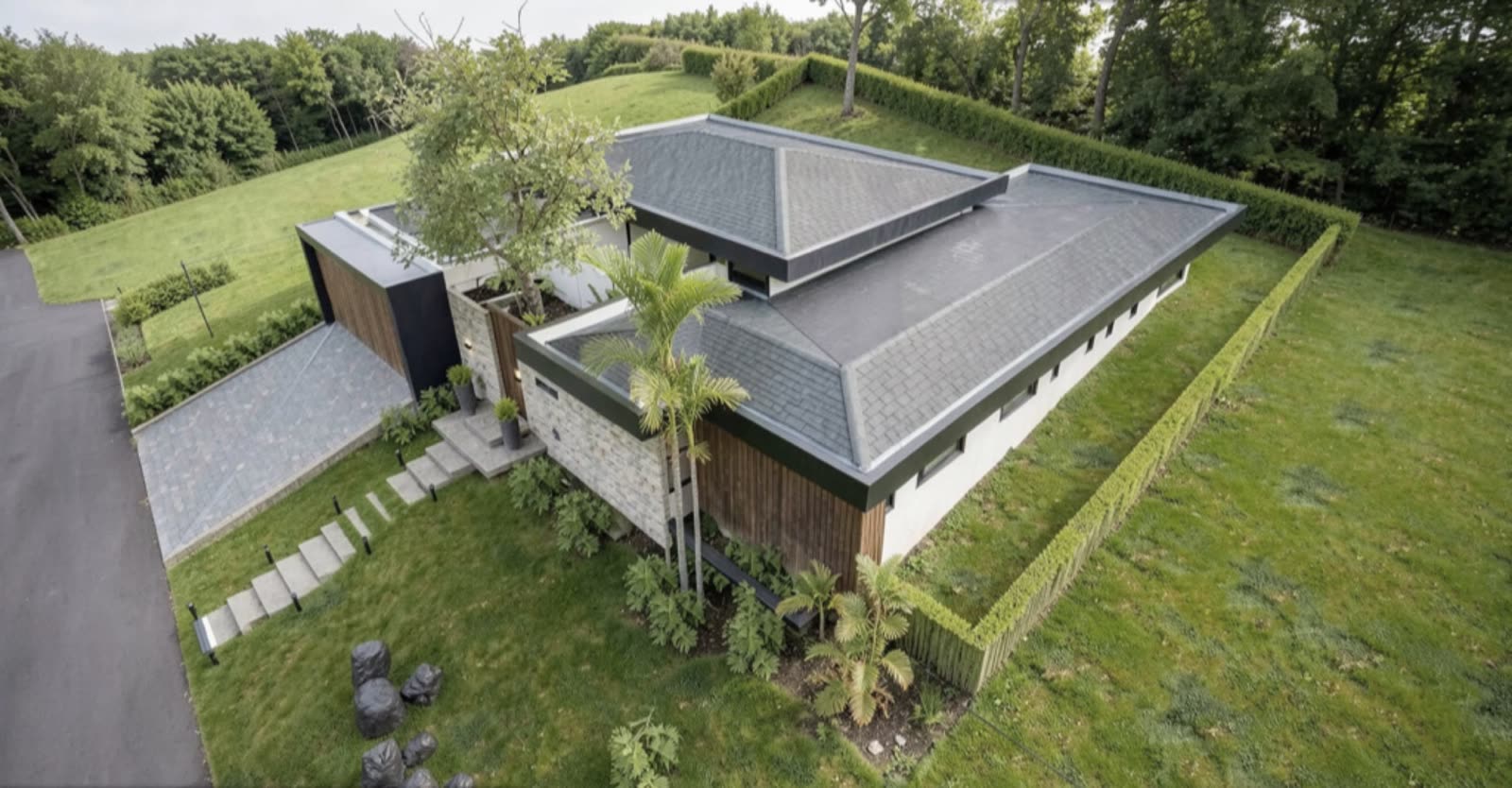 Aerial view of Casa Buenos Aires on its lawn, framed by a clipped hedge